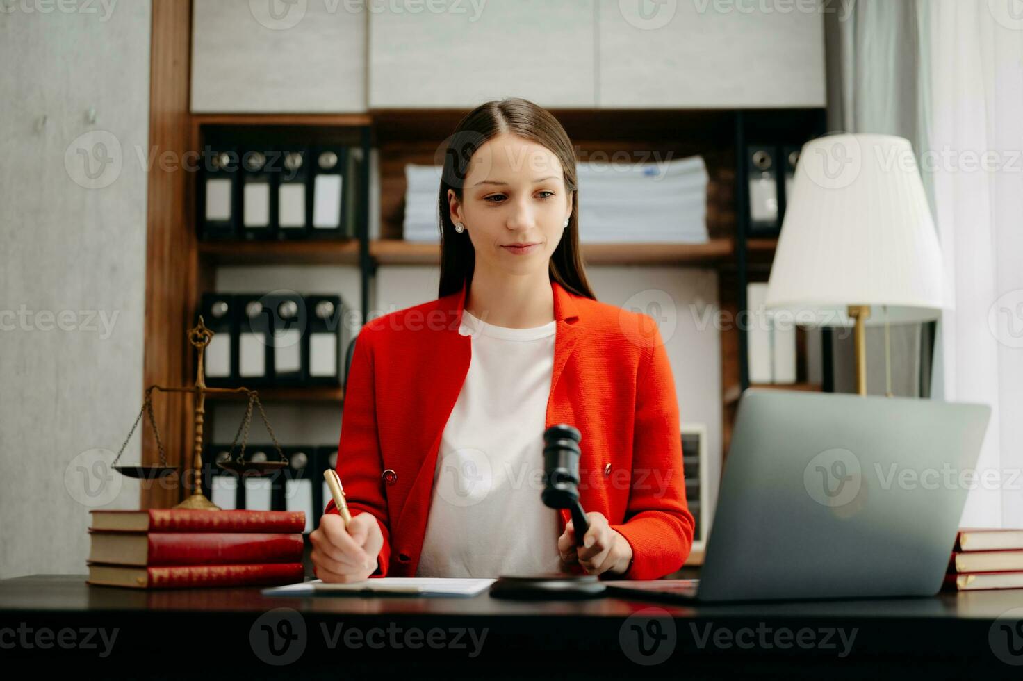 justice and law concept. Female judge in a courtroom  the gavel, working with smart phone and laptop and digital tablet computer on black  table photo