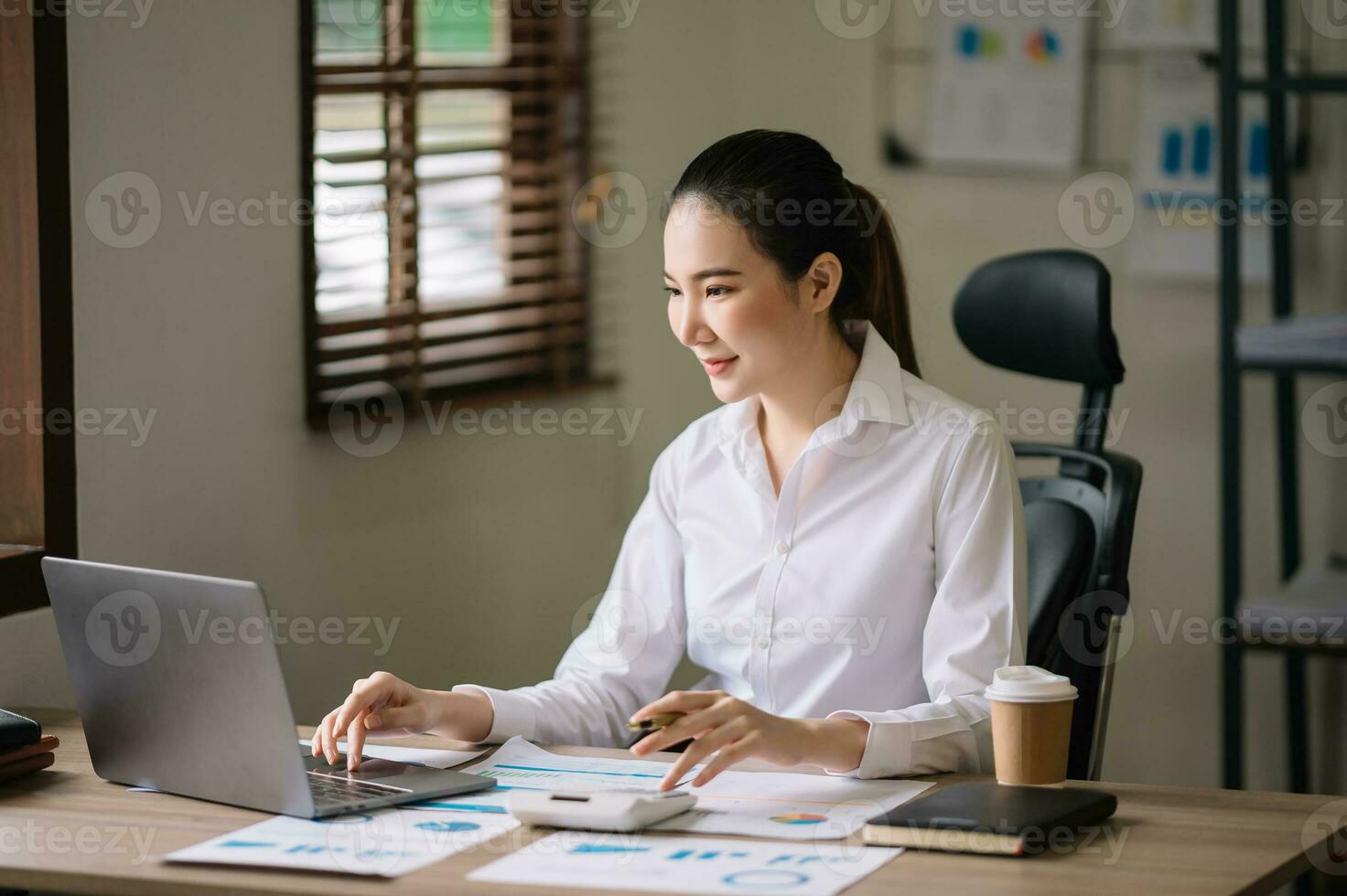 Asian businesswoman working in the office with working notepad, tablet and laptop documents photo