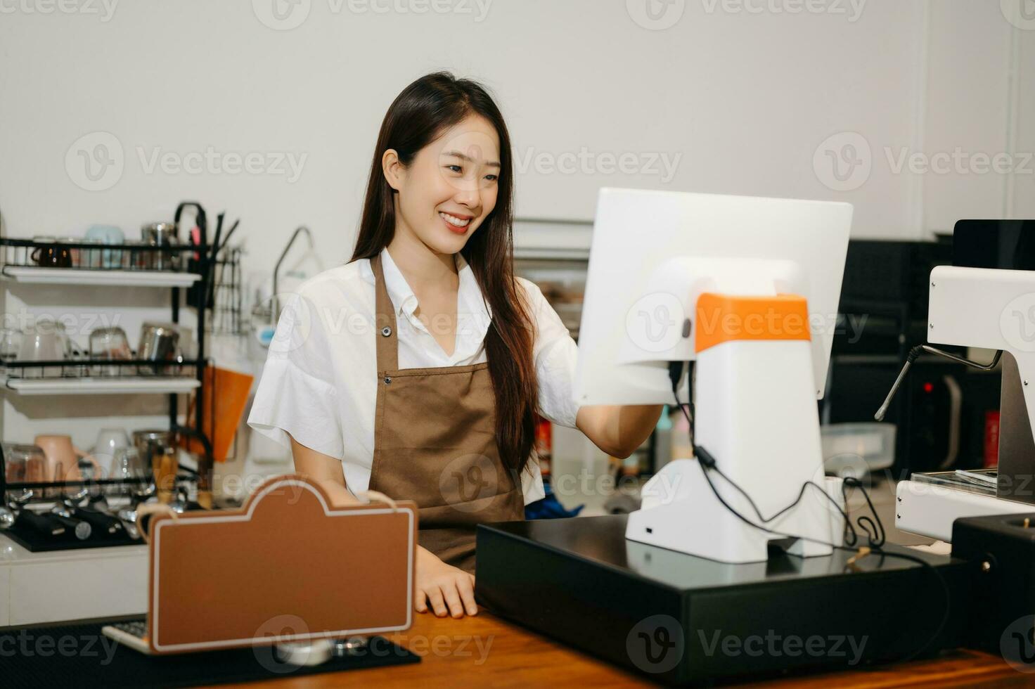 Asian female coffee shop owner in a coffee shop photo