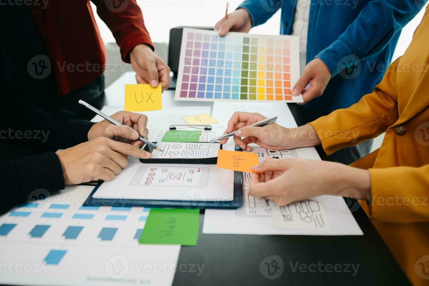 UX developer and ui designer brainstorming about mobile app interface wireframe design with customer breif and color code at office. photo