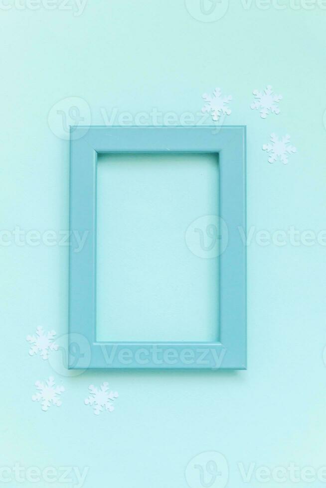 Simply minimal composition winter objects blue frame snowflakes isolated on blue pastel background photo