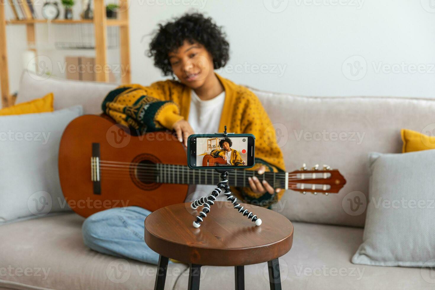 blogger guitarrista. africano americano niña blogger jugando guitarra hablando a cámara web grabación vlog. social medios de comunicación hombre de influencia mujer transmisión a hogar adentro. música contenido creador transmitir tutorial. foto