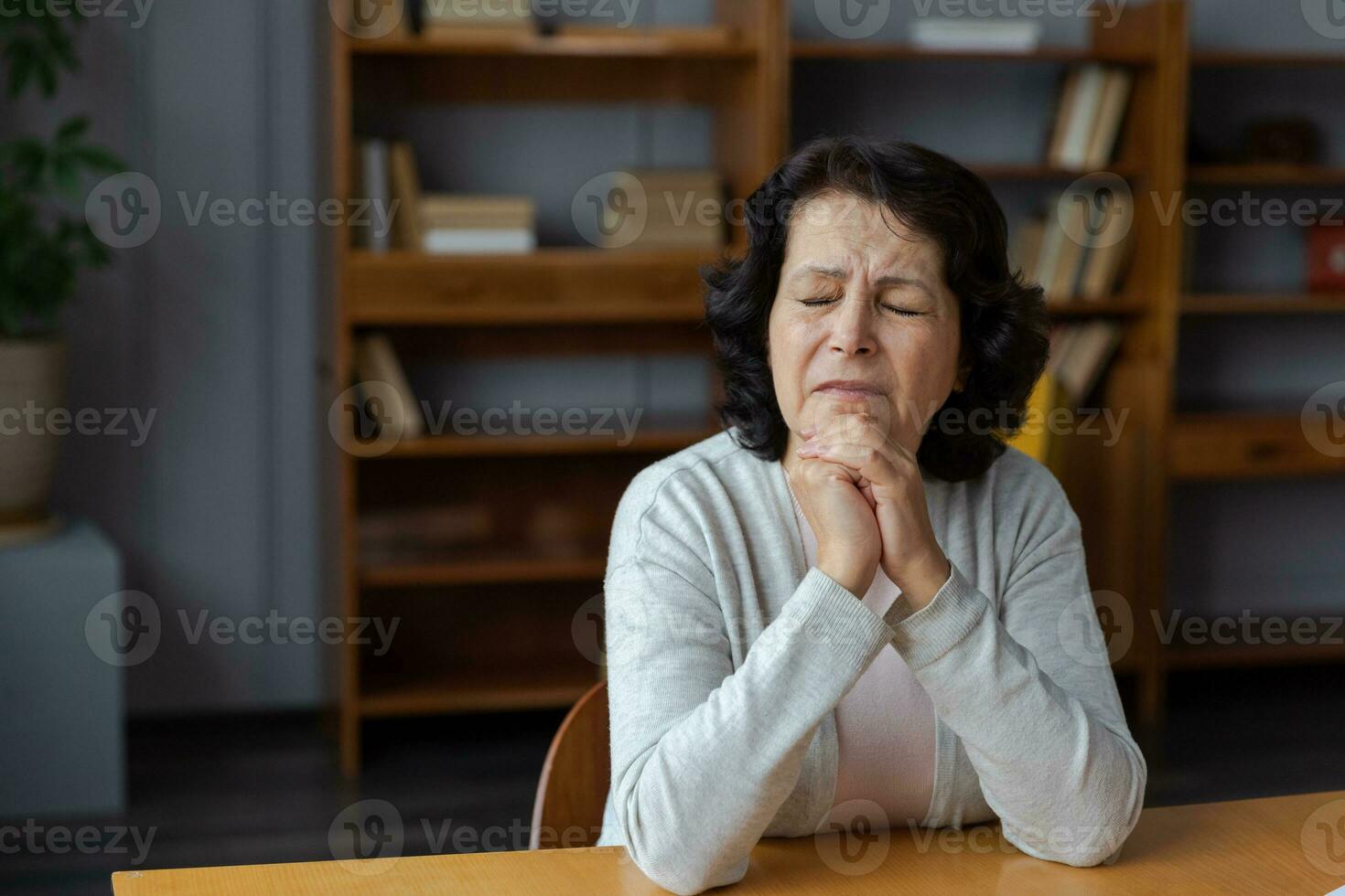 Sad tired ill sick lonely disappointed older senior woman sitting at home alone. Unhappy mature grandmother experiencing grief relative death bad news. Stressed elder lady suffering from loneliness. photo