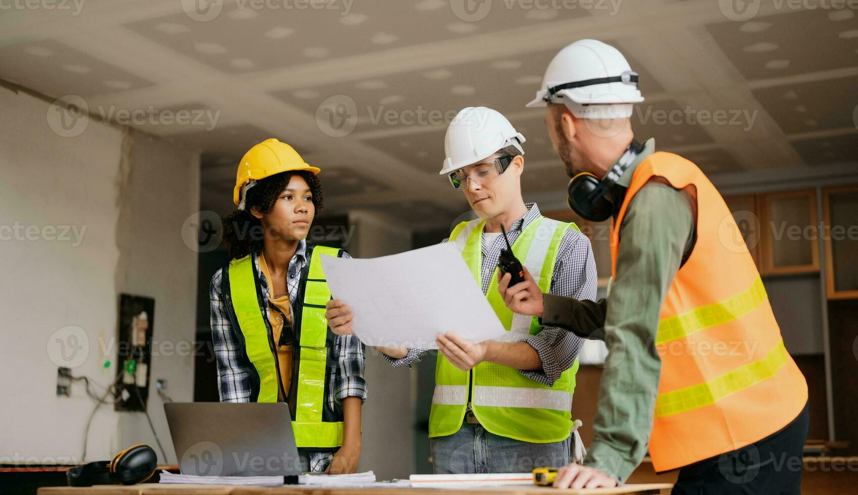 Architect caucasian man and woman working with colleagues mixed race in the construction site. Architecture engineering on big project. Building in construction process interior. photo