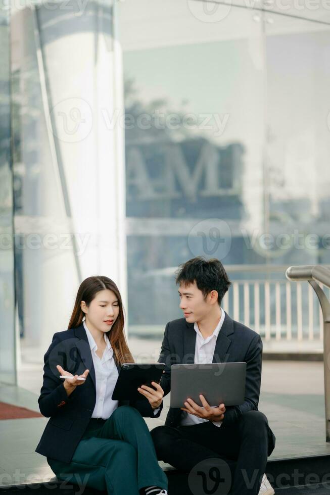 Businesswoman and man walking and talking on street in city Outside Office with ,young couple discussing and drinking coffee together, partners, teamwork photo