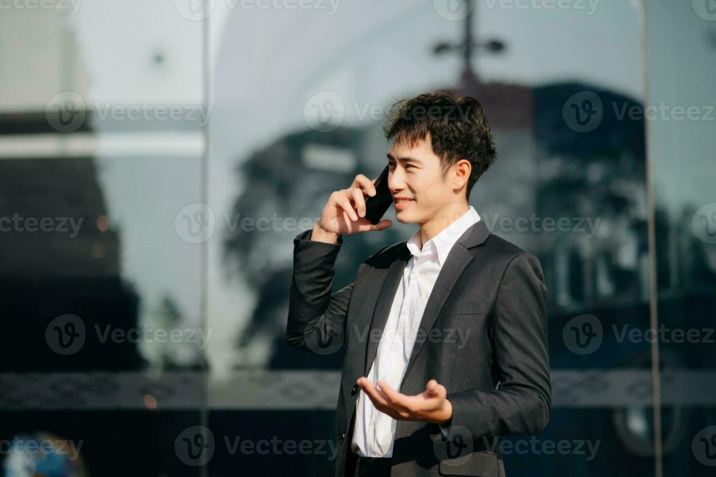 Young Asian business man working at outside business center with laptop, tablet, smartphone  and taking notes on the paper. photo