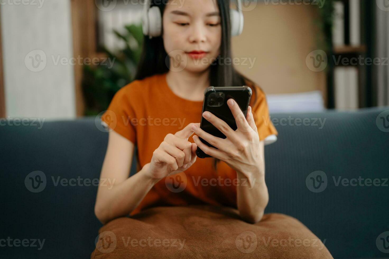 Woman using smart phone for mobile payments online shopping, omni channel, sitting on table, virtual icons graphics interface screen photo