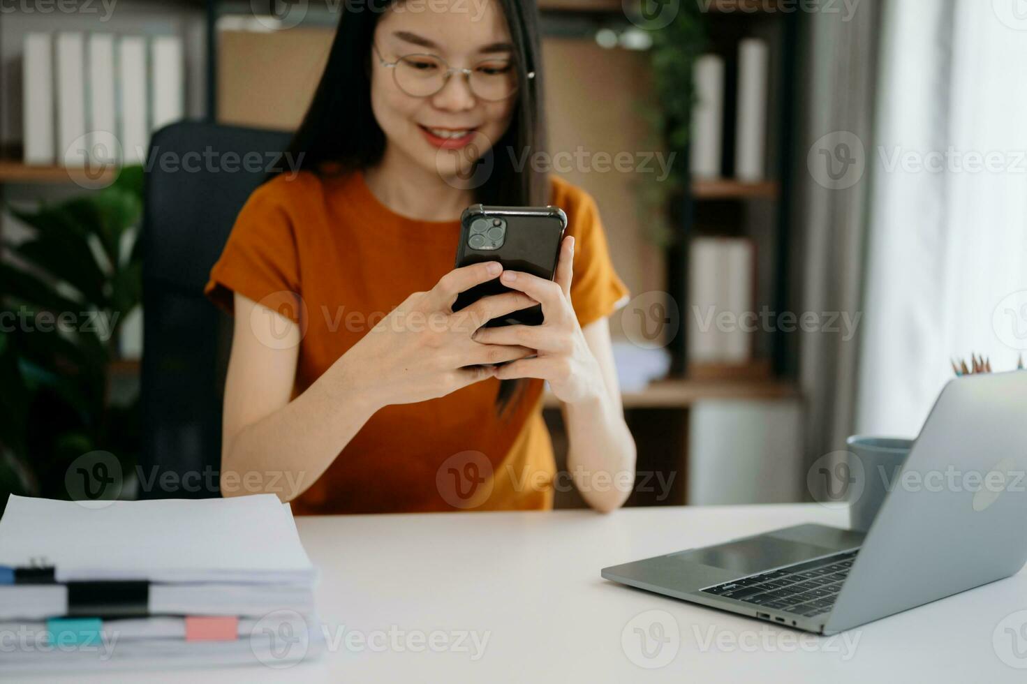 Woman using smart phone for mobile payments online shopping, omni channel, sitting on table, virtual icons graphics interface screen photo
