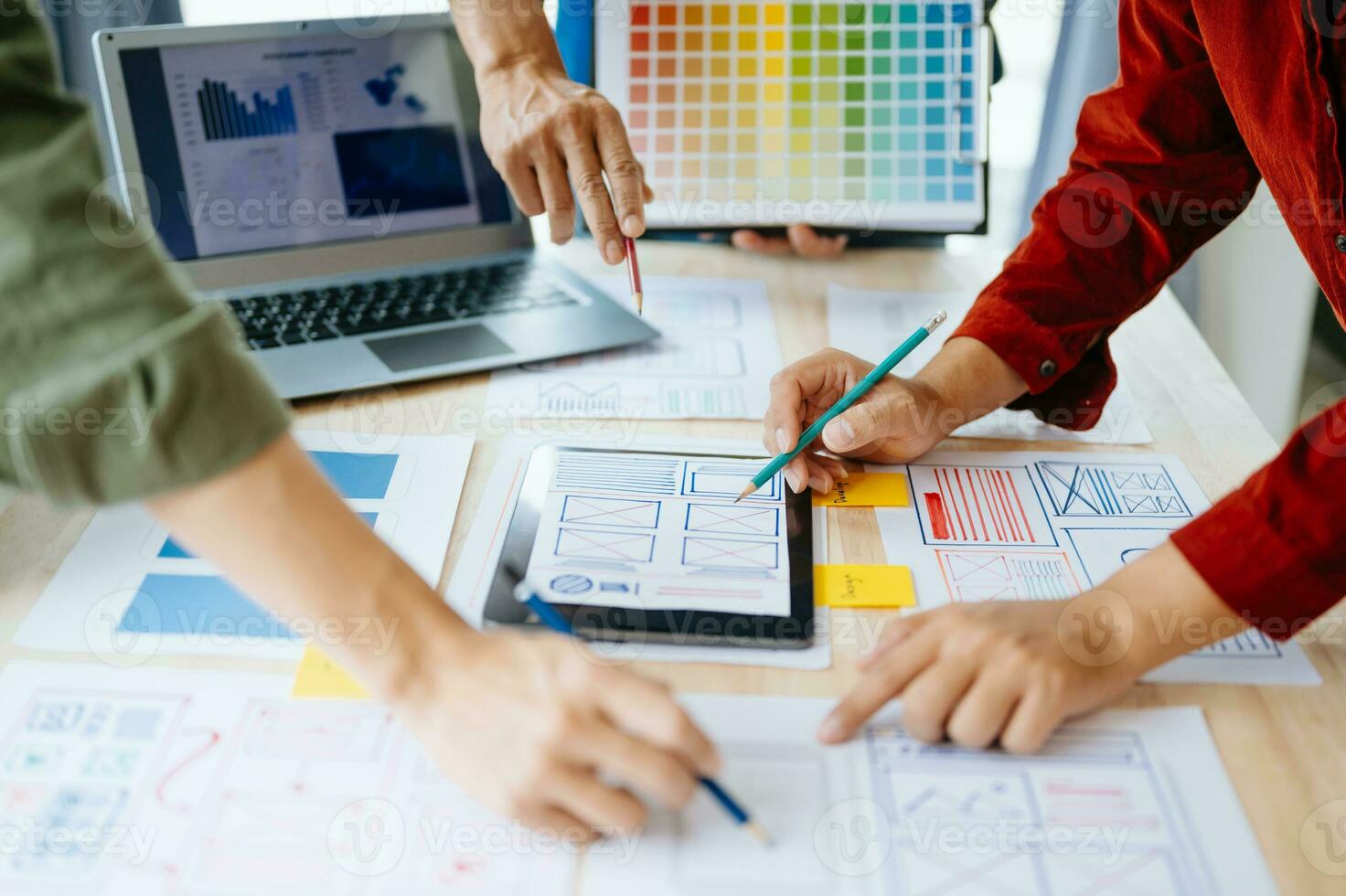 UX developer and ui designer brainstorming about mobile app interface wireframe design with customer breif and color code at office. photo