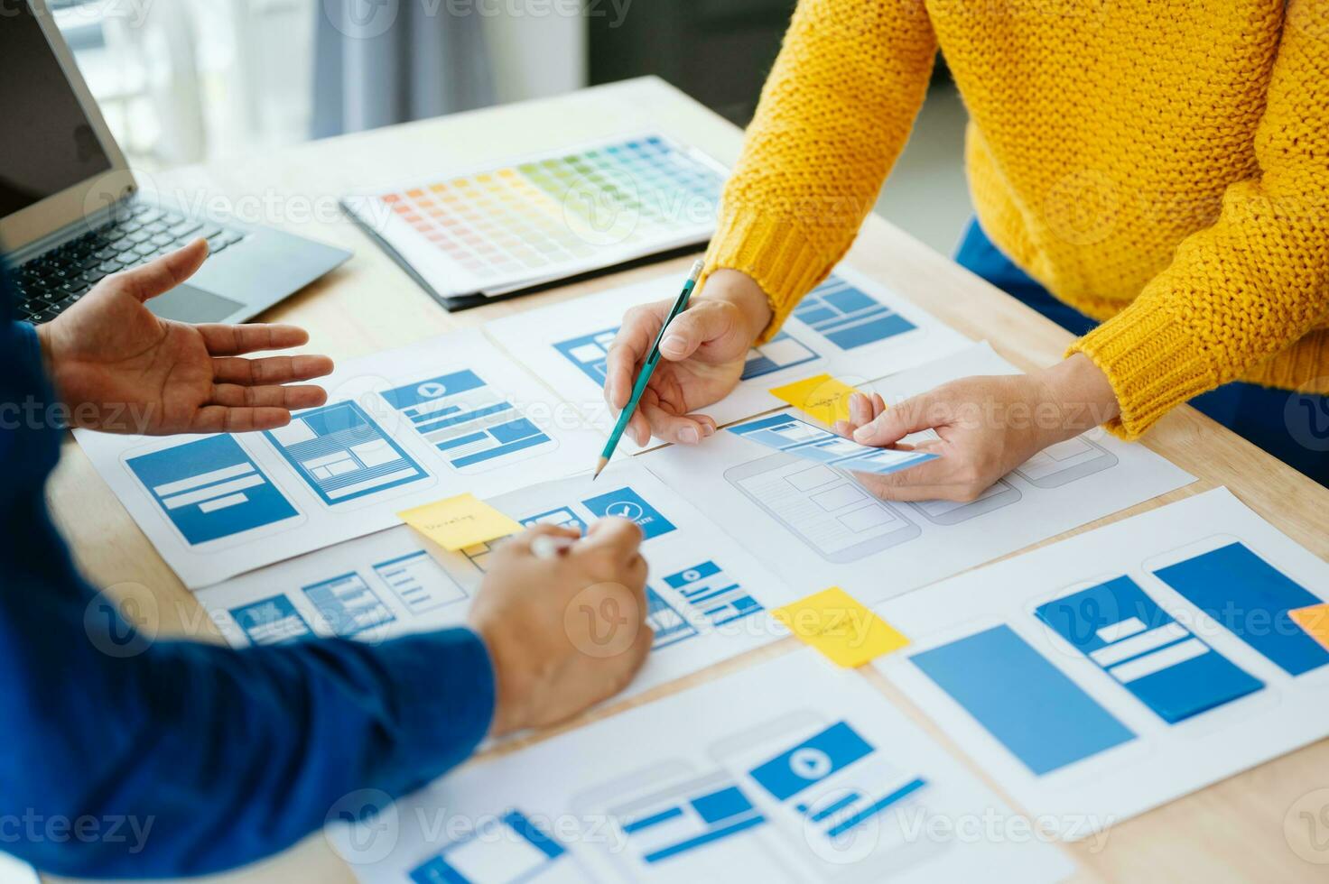 UX developer and ui designer brainstorming about mobile app interface wireframe design with customer breif and color code at office. photo