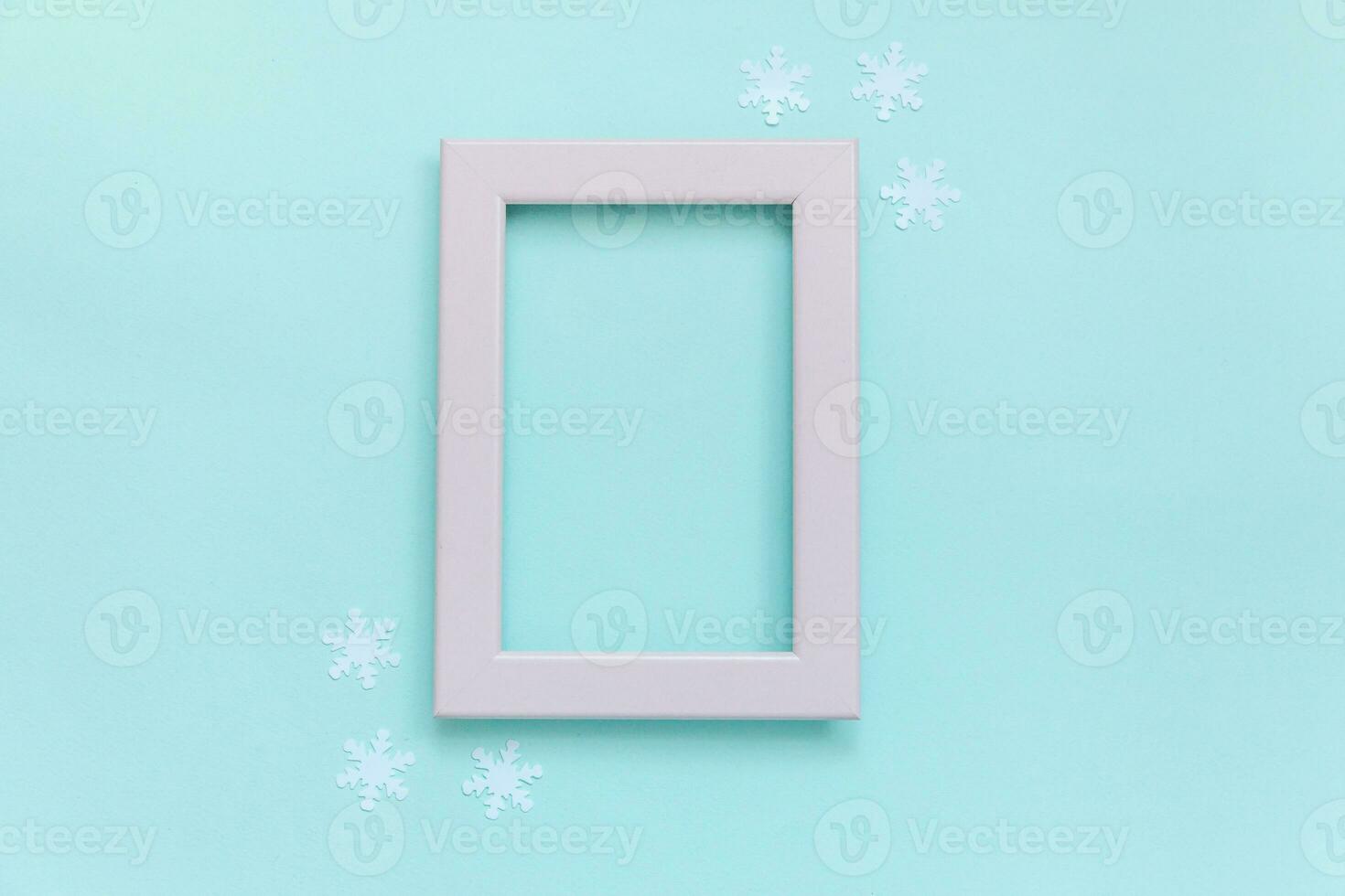 Simply minimal composition winter objects pink frame snowflakes isolated on blue pastel background photo