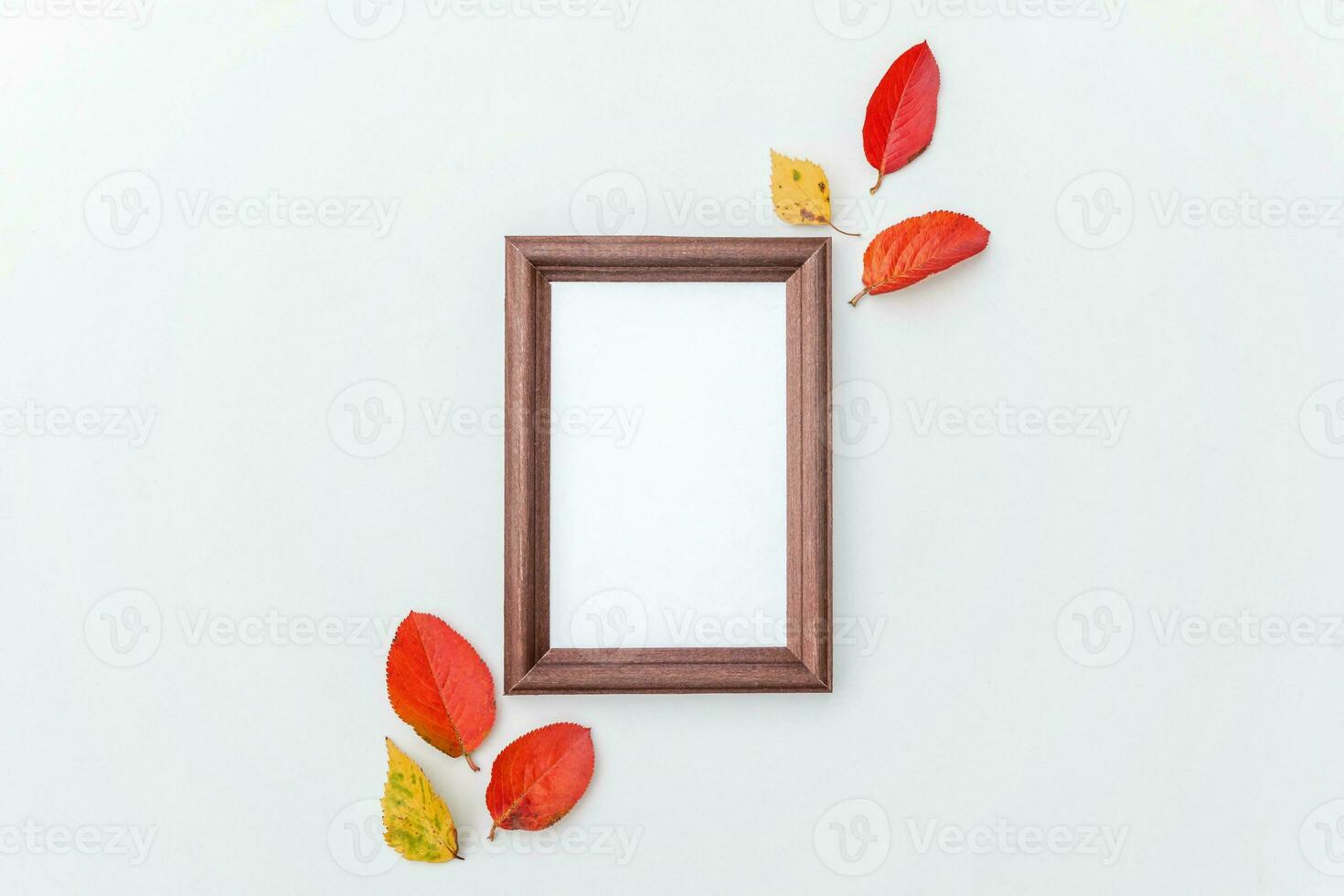 Autumn floral composition. Vertical photo frame mockup and colorful leaves on white background. Fall natural plants ecology fresh wallpaper concept. Flat lay top view, copy space