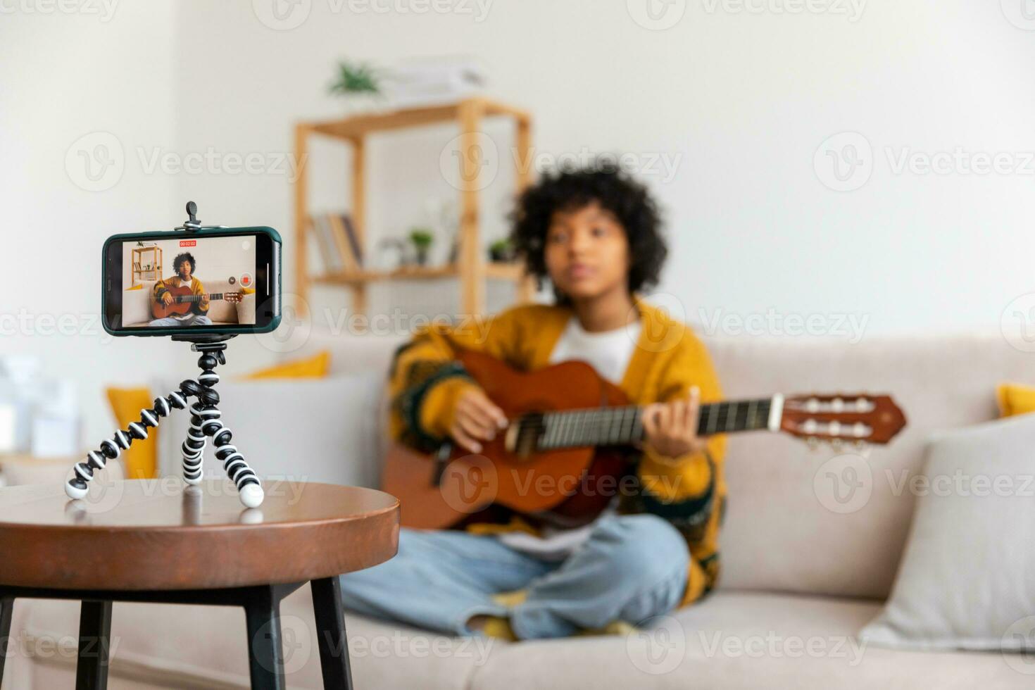 Blogger guitarist. Happy african american girl blogger playing guitar singing song recording vlog. Social media influencer woman streaming recording at home studio. Music content creator broadcast. photo