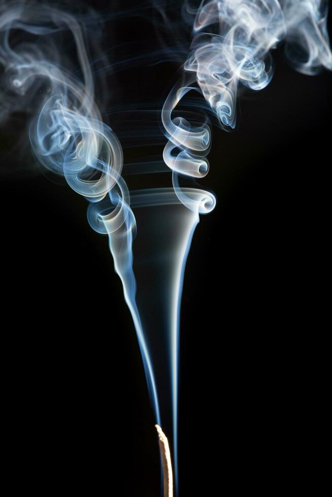 Abstract image of twisting incense smoke on a black background. photo