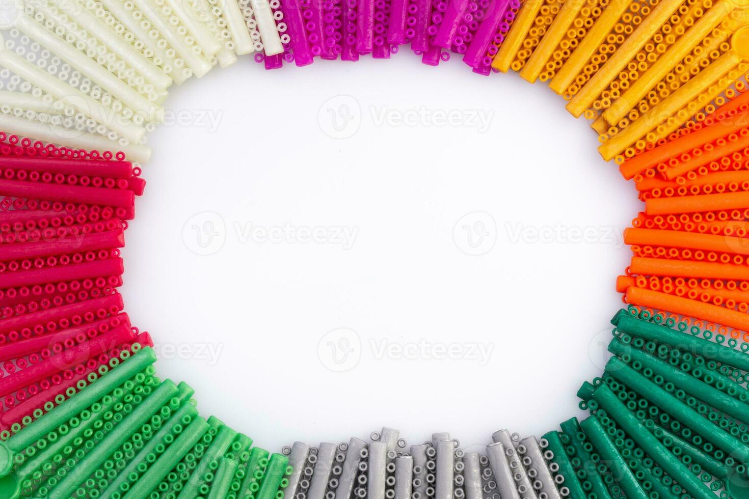 group of colorful O-rings for use with brackets for orthodontics dental.O-rings arranged in a circular shape with a white background area in the middle. photo