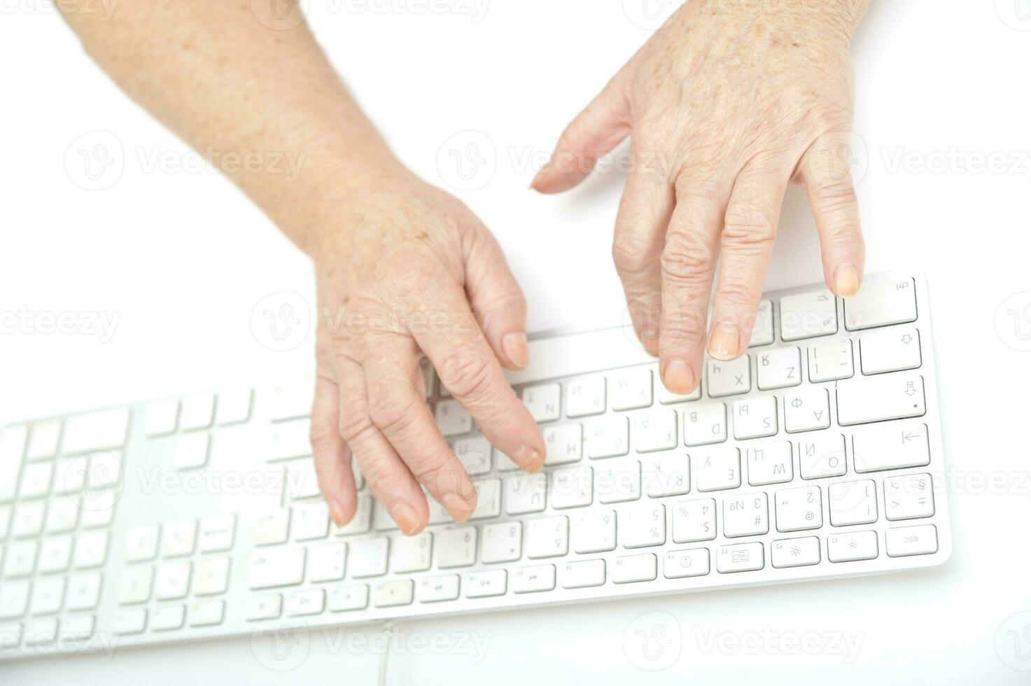 manos de un antiguo hembra mecanografía en el teclado, aislado en blanco, de cerca. foto