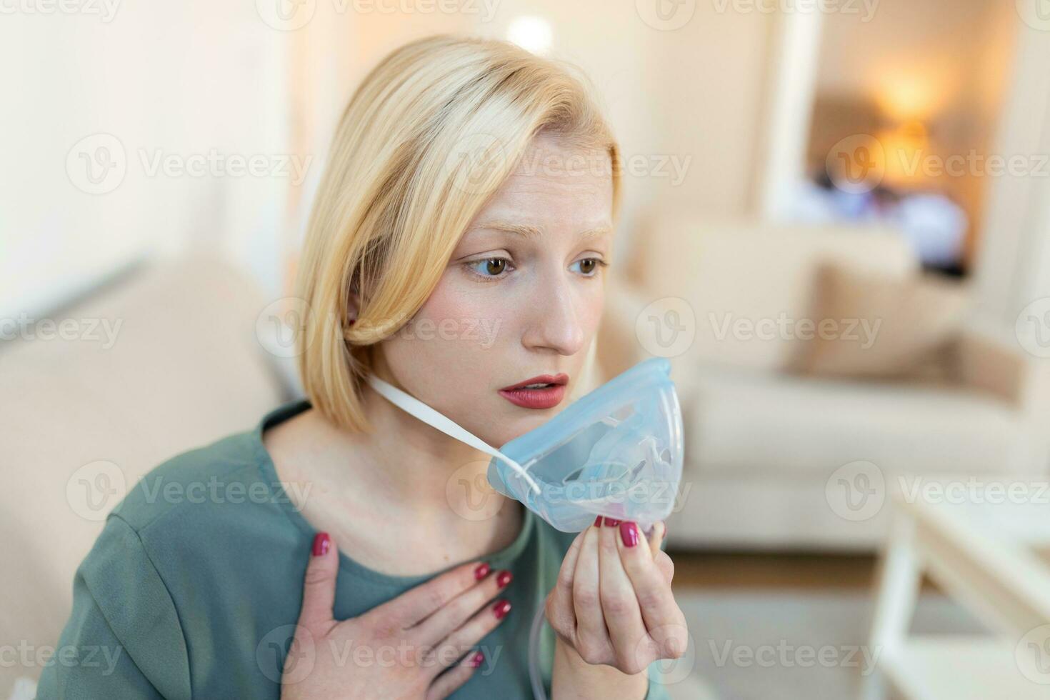 Sick woman making inhalation, medicine is the best medicine. Ill woman wearing an oxygen mask and undergoing treatment for covid-19. woman with an inhaler photo