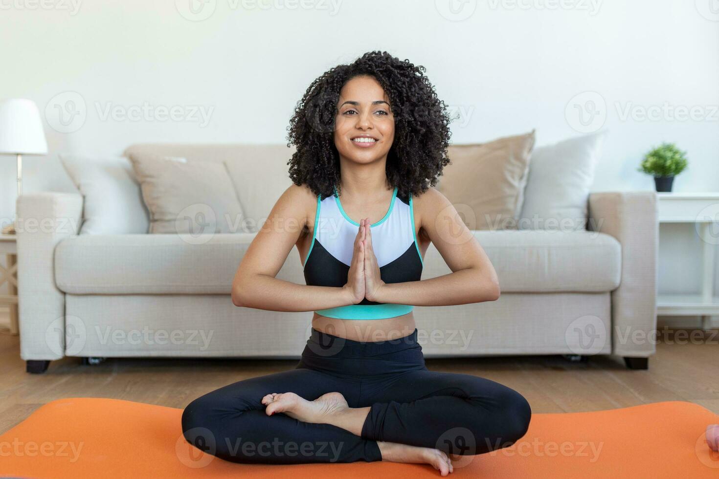 mujer hermosa joven en la posición de oración. mujer practicando yoga, relajándose en posición de oración en la alfombra, haciendo ejercicio padmasana usando ropa deportiva haciendo ejercicio, meditando en el estudio de yoga o en casa foto