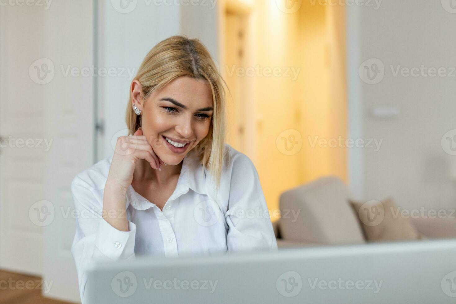 Happy blond woman looking at webcam, smiling at camera, laughing during virtual meeting or video call talk. Employee working from home. Screen view head shot photo