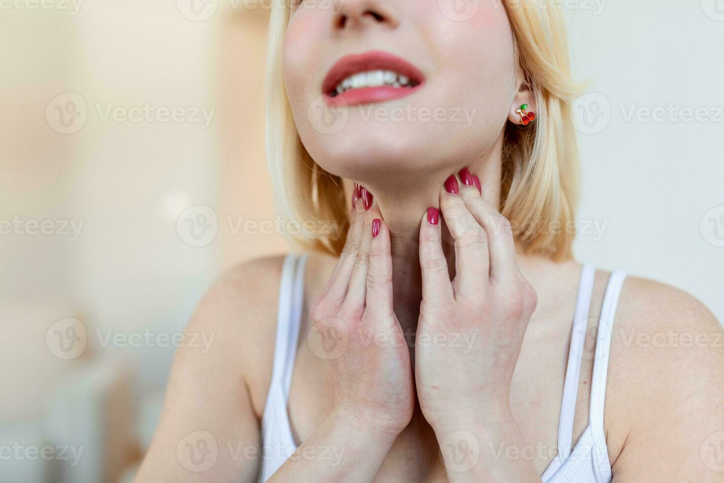 Close up of young woman rubbing her inflamed tonsils, tonsilitis problem, cropped. Woman with thyroid gland problem, touching her neck, girl has a sore throat photo