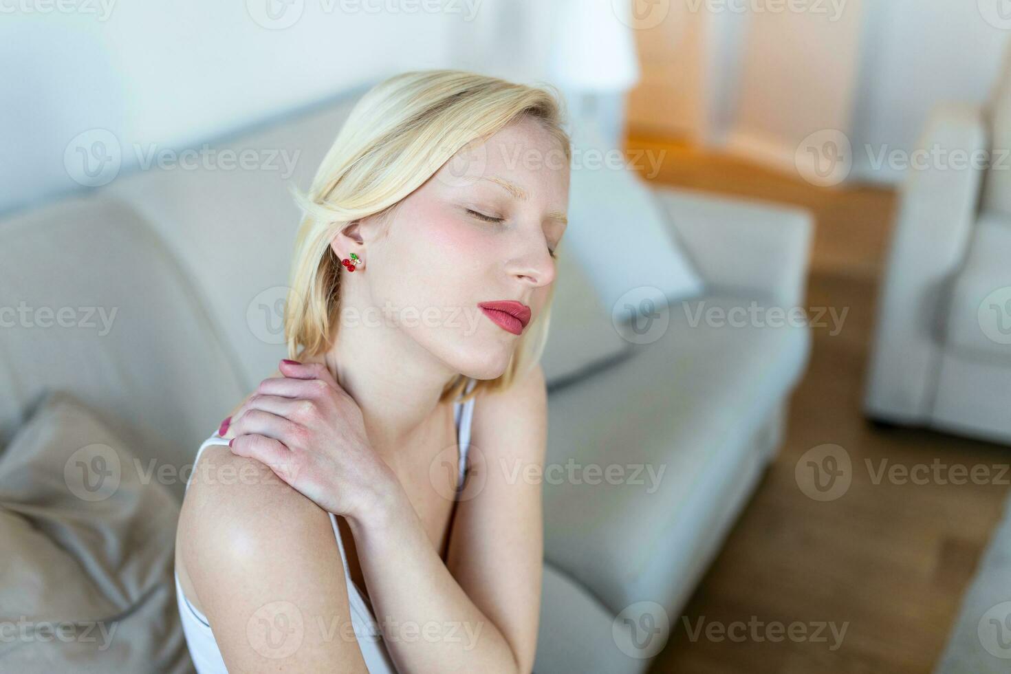 Tired woman massaging stiff sore neck, tensed muscles fatigued from computer work in incorrect posture while feeling hurt joint shoulder back pain ache. Fibromyalgia concept photo