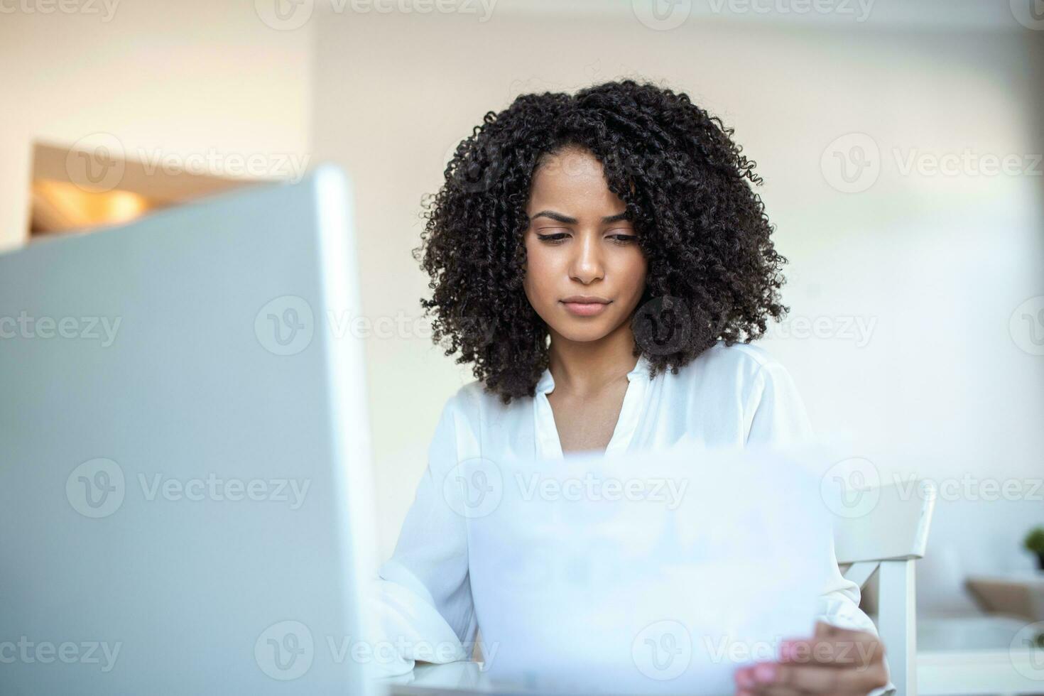 Business professionals. Business woman analyzing data using computer while spending time in the office. Beautiful young grinning professional Black woman in office. Graphs and charts photo