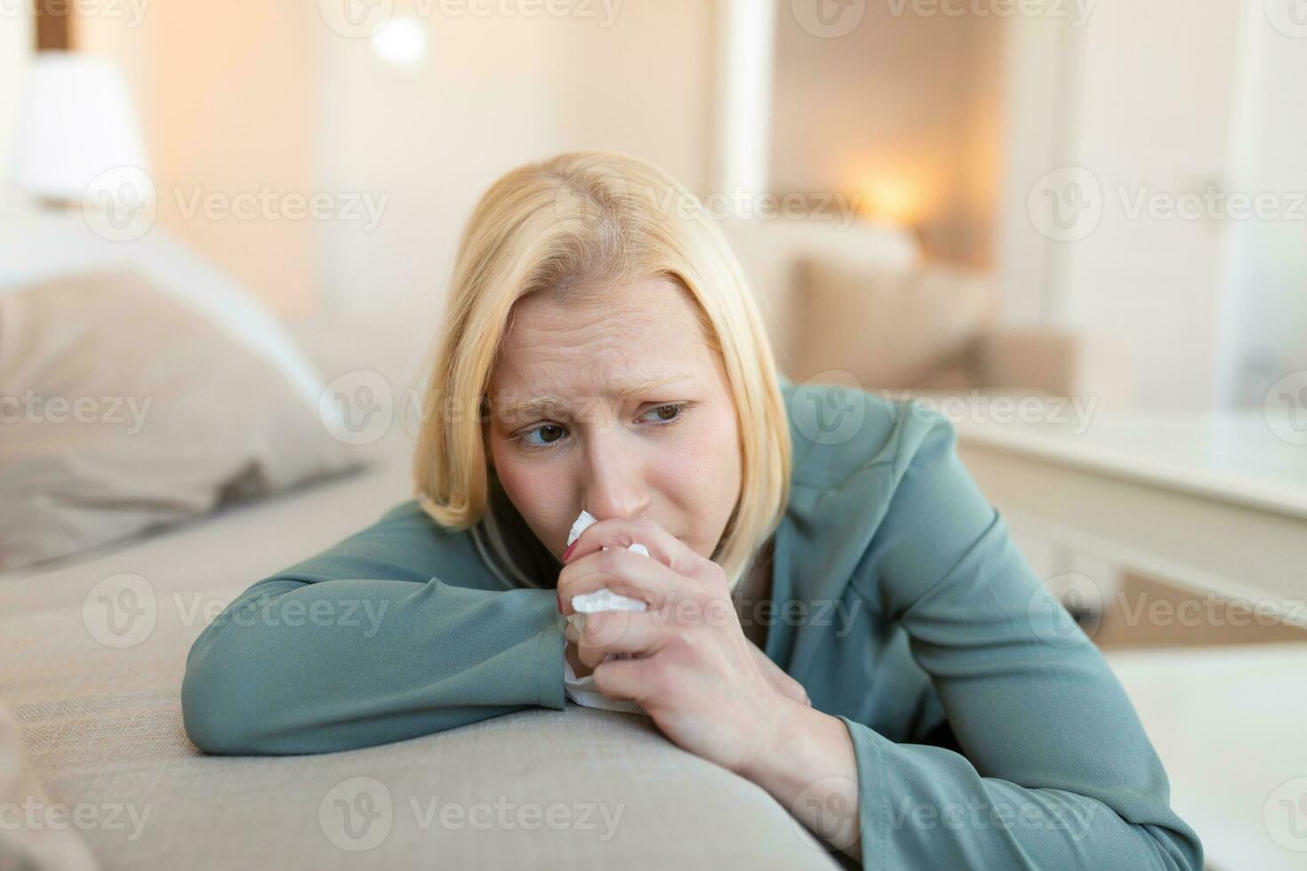 Unhappy young woman covering face with hands, crying alone close up, depressed girl sitting on couch at home, health problem or thinking about bad relationships, break up with boyfriend, divorce photo