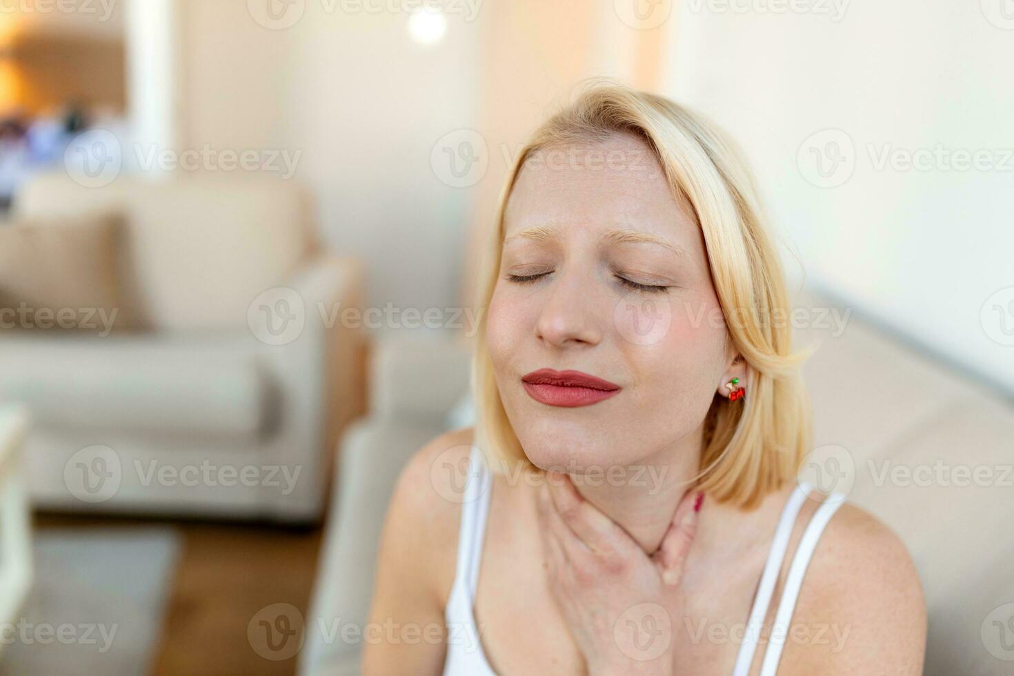 Close up of young woman rubbing her inflamed tonsils, tonsilitis problem, cropped. Woman with thyroid gland problem, touching her neck, girl has a sore throat photo