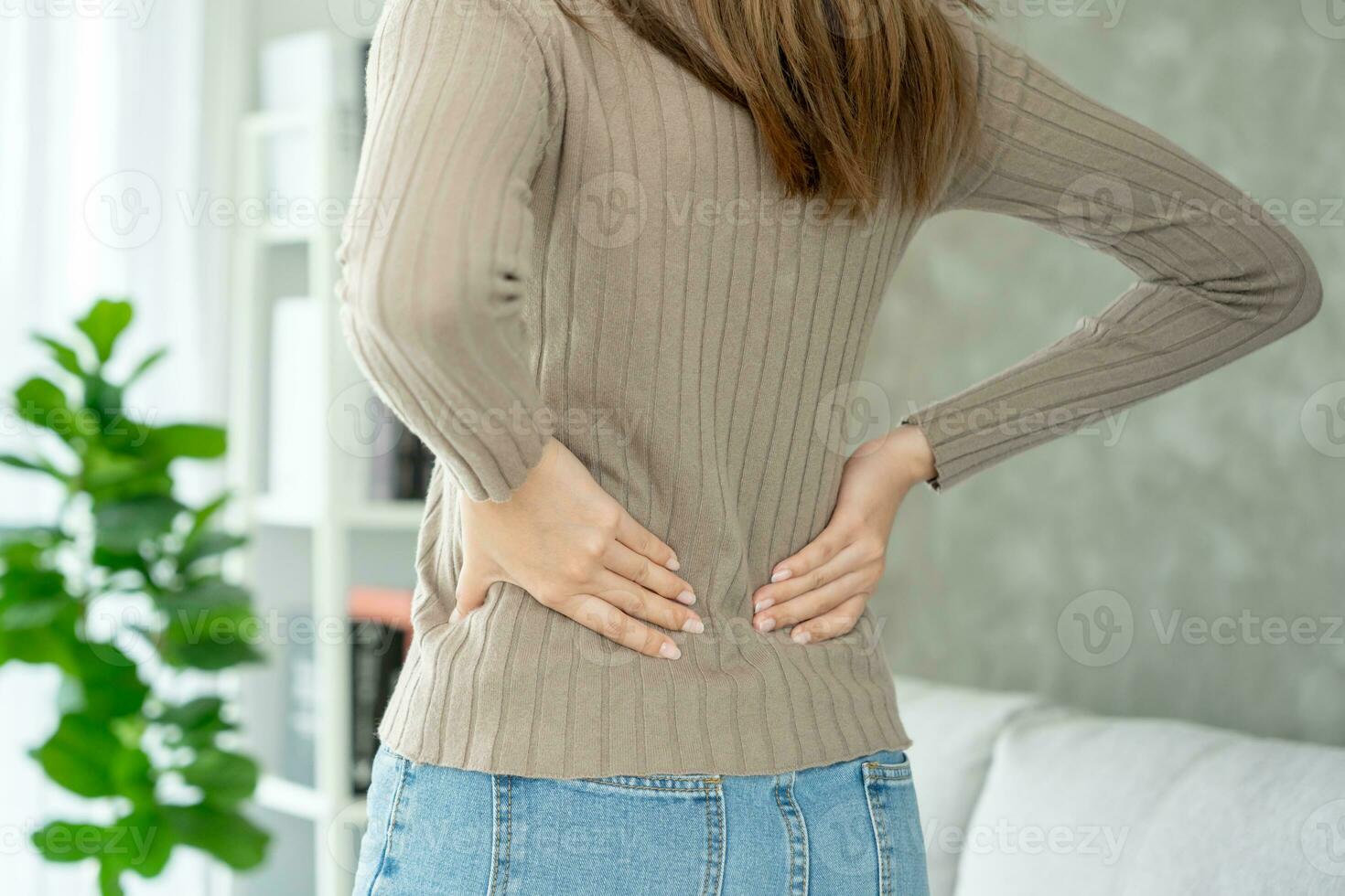 Asia hermosa mujer participación su inferior espalda mientras y sufrir desde inaguantable dolor salud y problemas, crónico espalda dolor, dolor de espalda en oficina síndrome, escoliosis, herniado desct, músculo inflamación foto