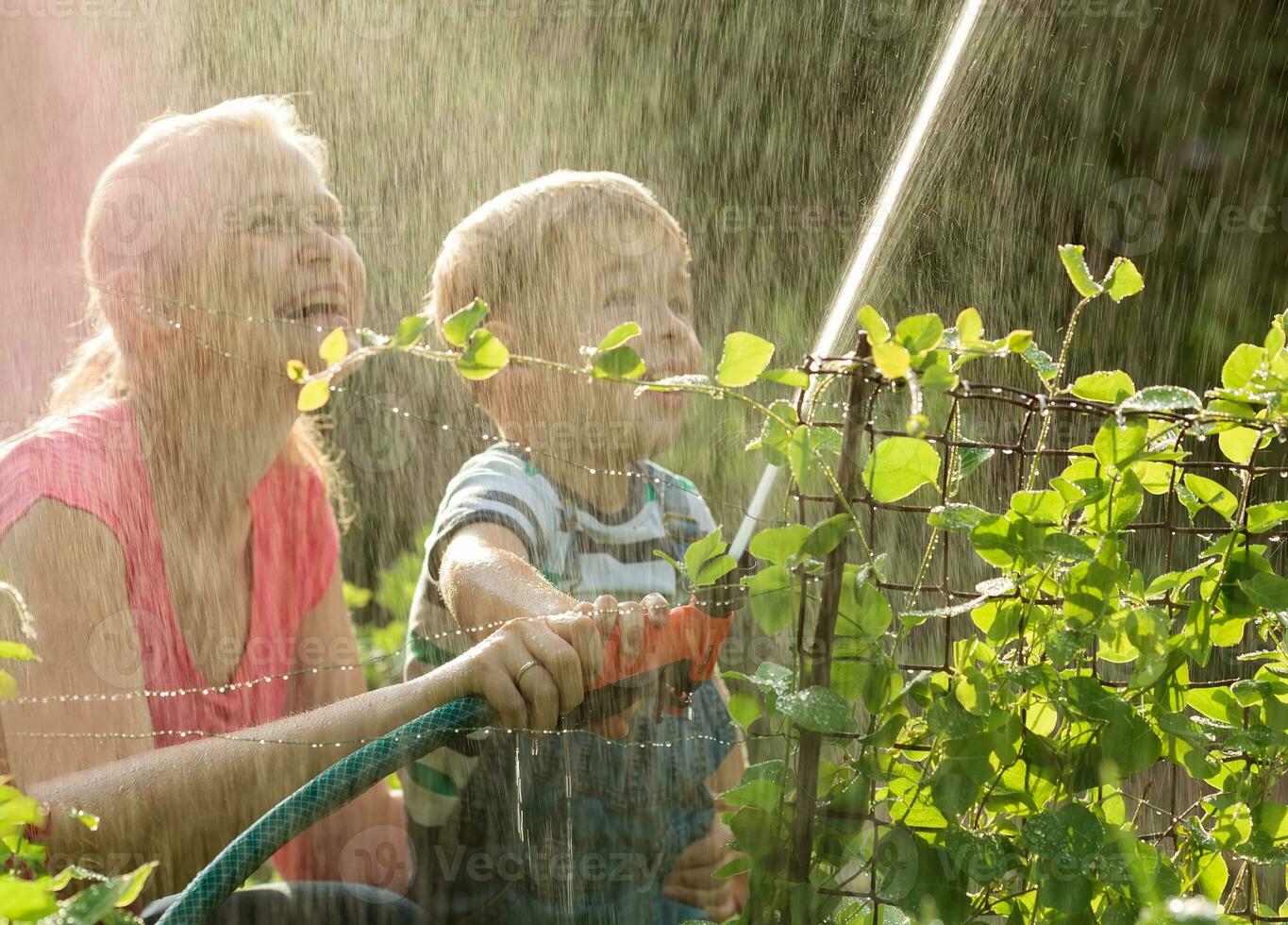 Mother and her young son playing with water photo