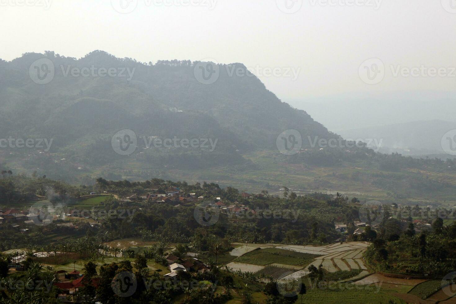 View of a mountain covered in mist and clear clouds photo