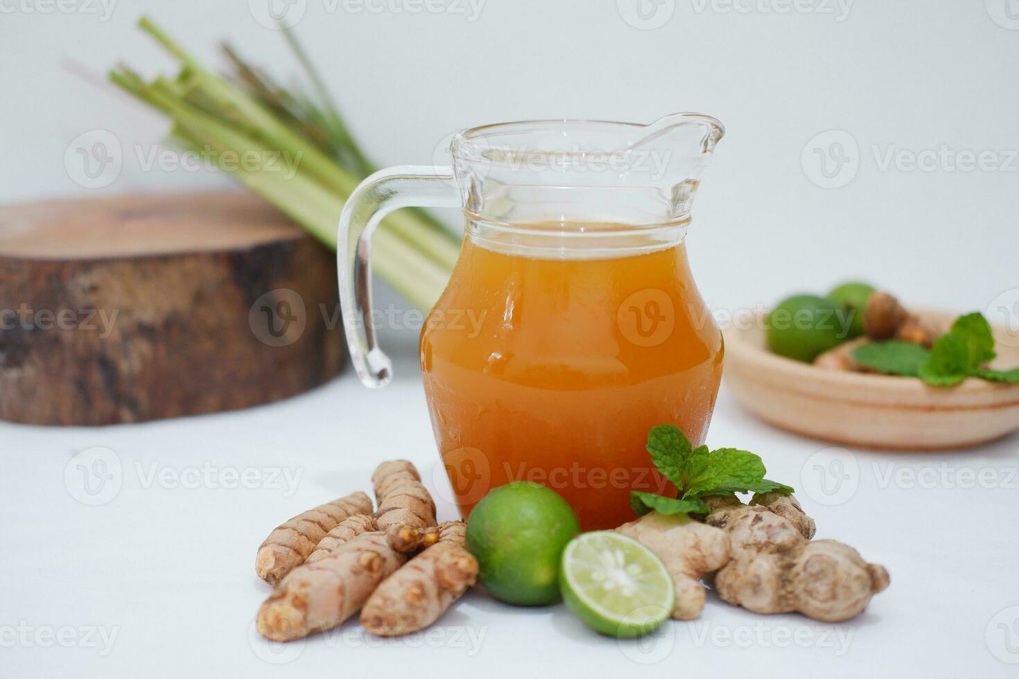 Ginger juice with fresh ginger and lemon on white background. Healthy drink. photo