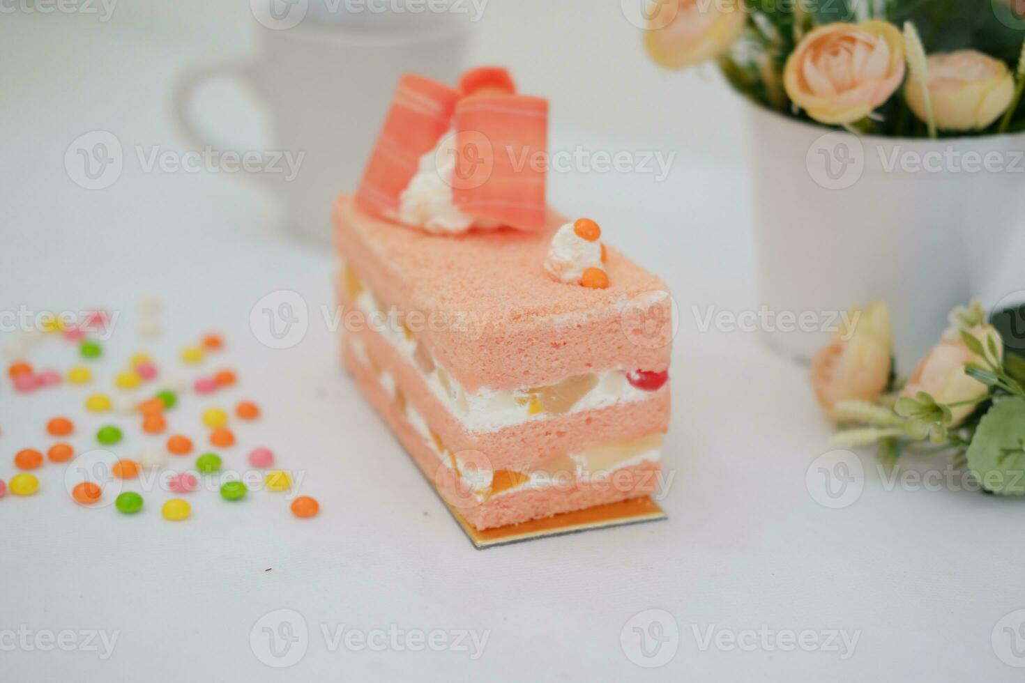 Piece of cake and cup of tea on white background, stock photo