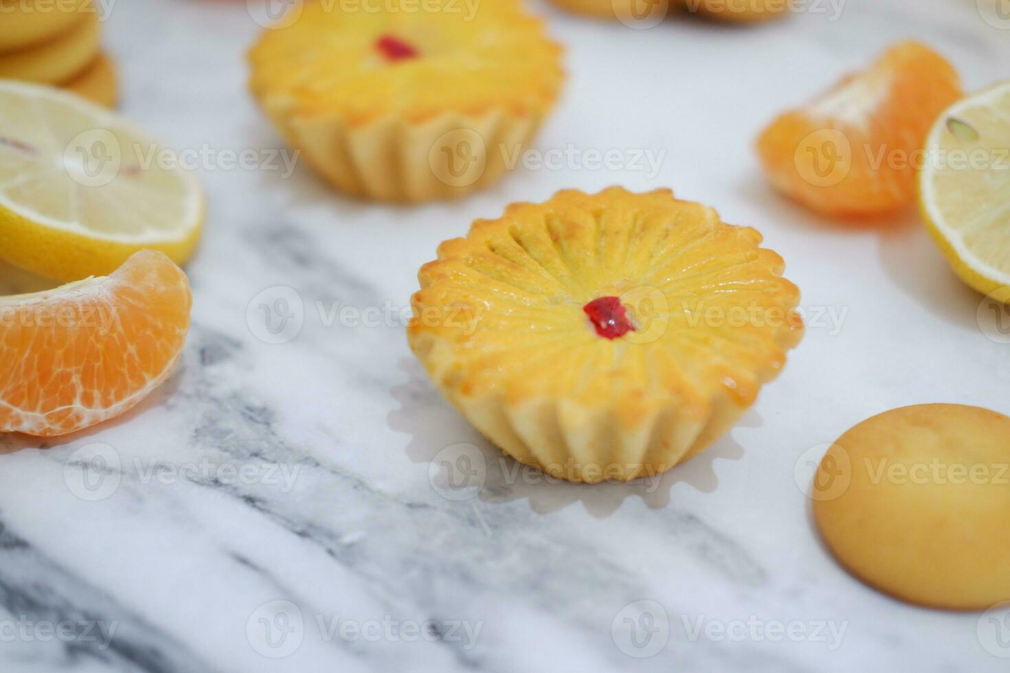Lemon tartlets with fresh lemons and tangerines. photo