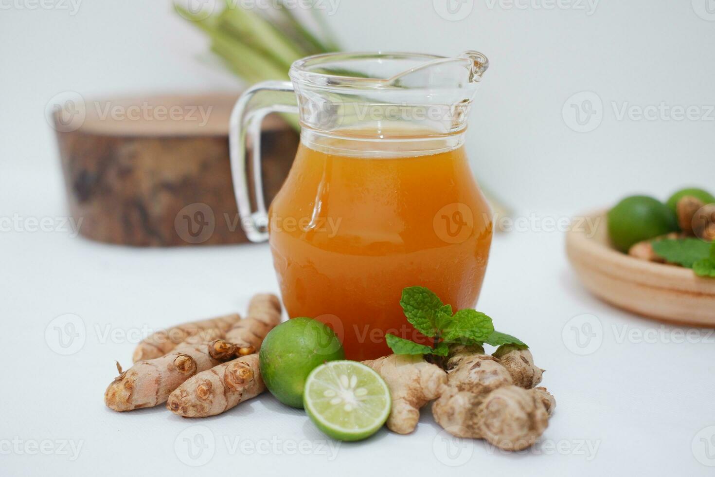 Ginger juice with fresh ginger and lemon on white background. Healthy drink. photo