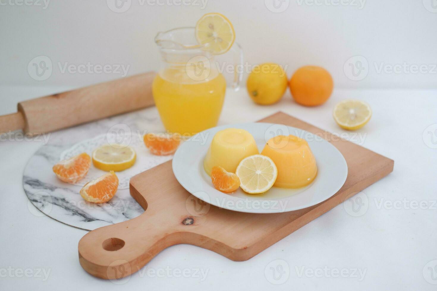 Orange jelly with fresh lemon and orange juice on a white background. photo