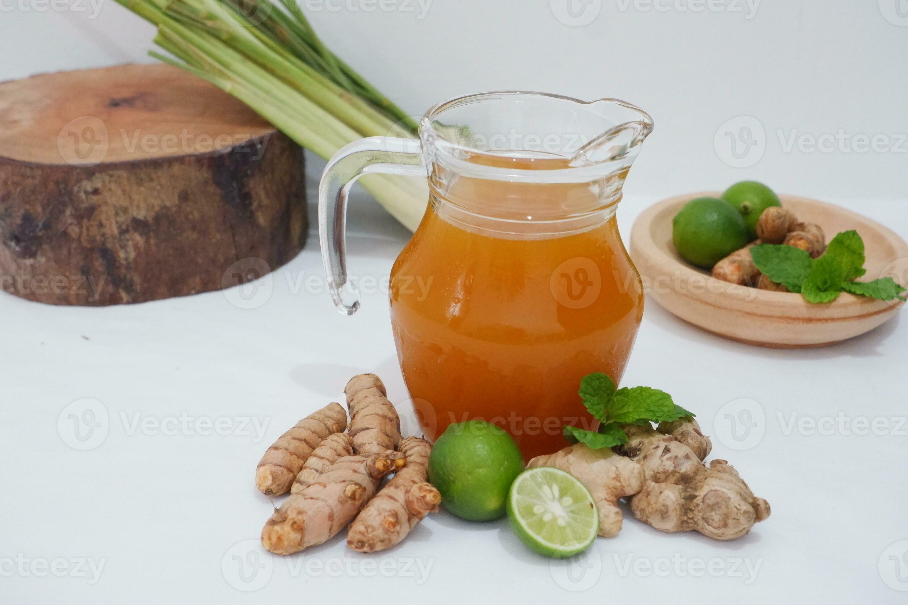 Ginger juice with fresh ginger and lemon on white background. Healthy
