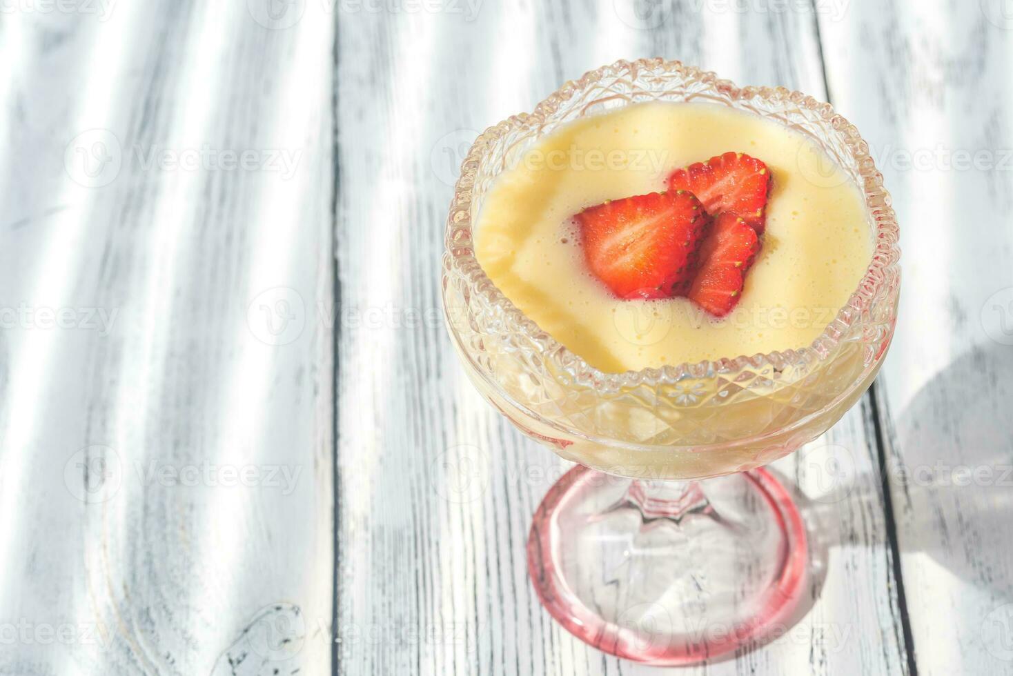 Sabayon with strawberry slices on the wooden background photo