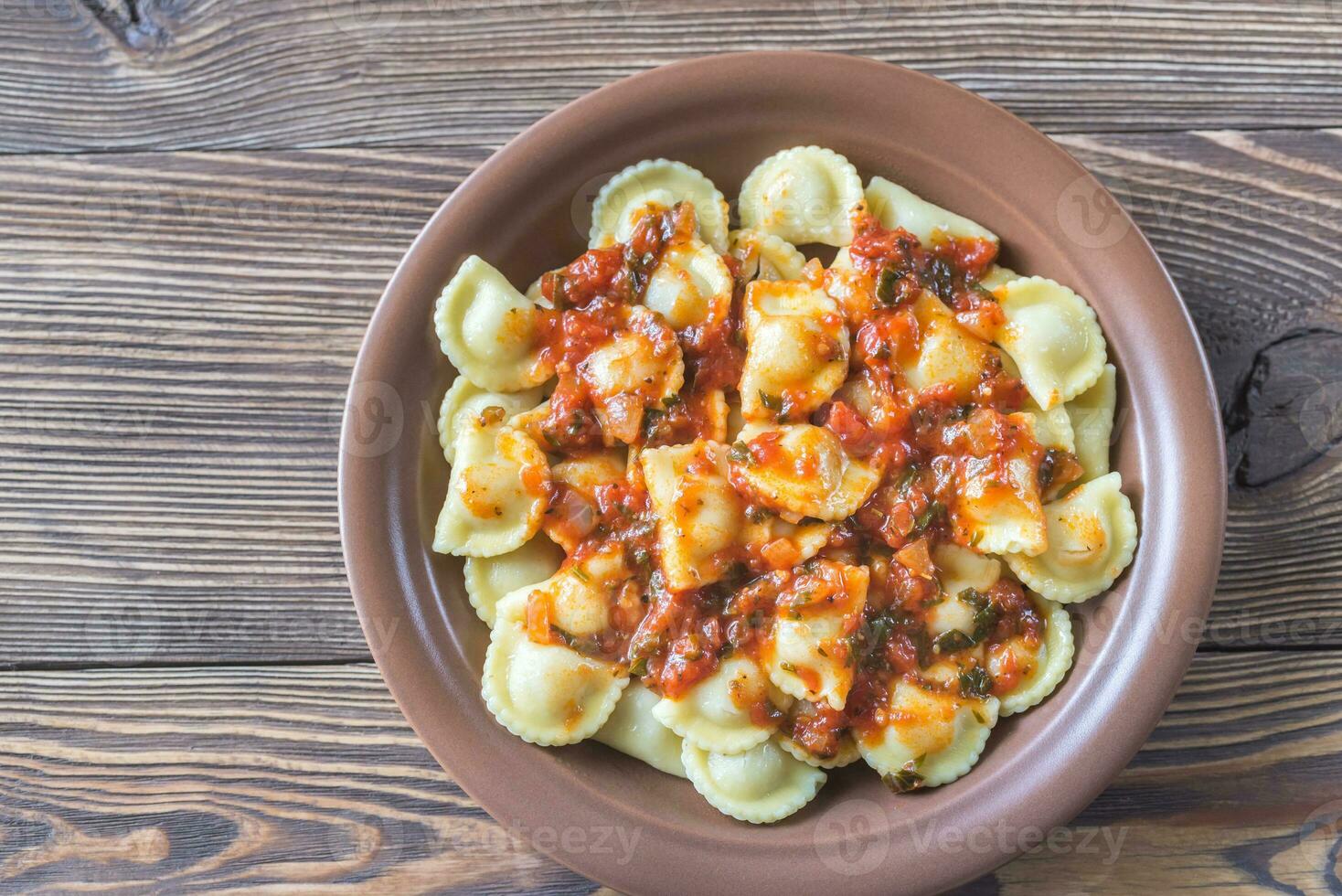 Portion of ravioli with marinara sauce photo