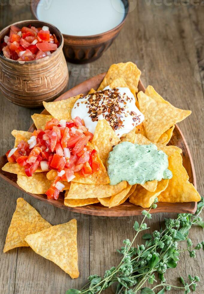 Cheese nachos with different types of sauce photo