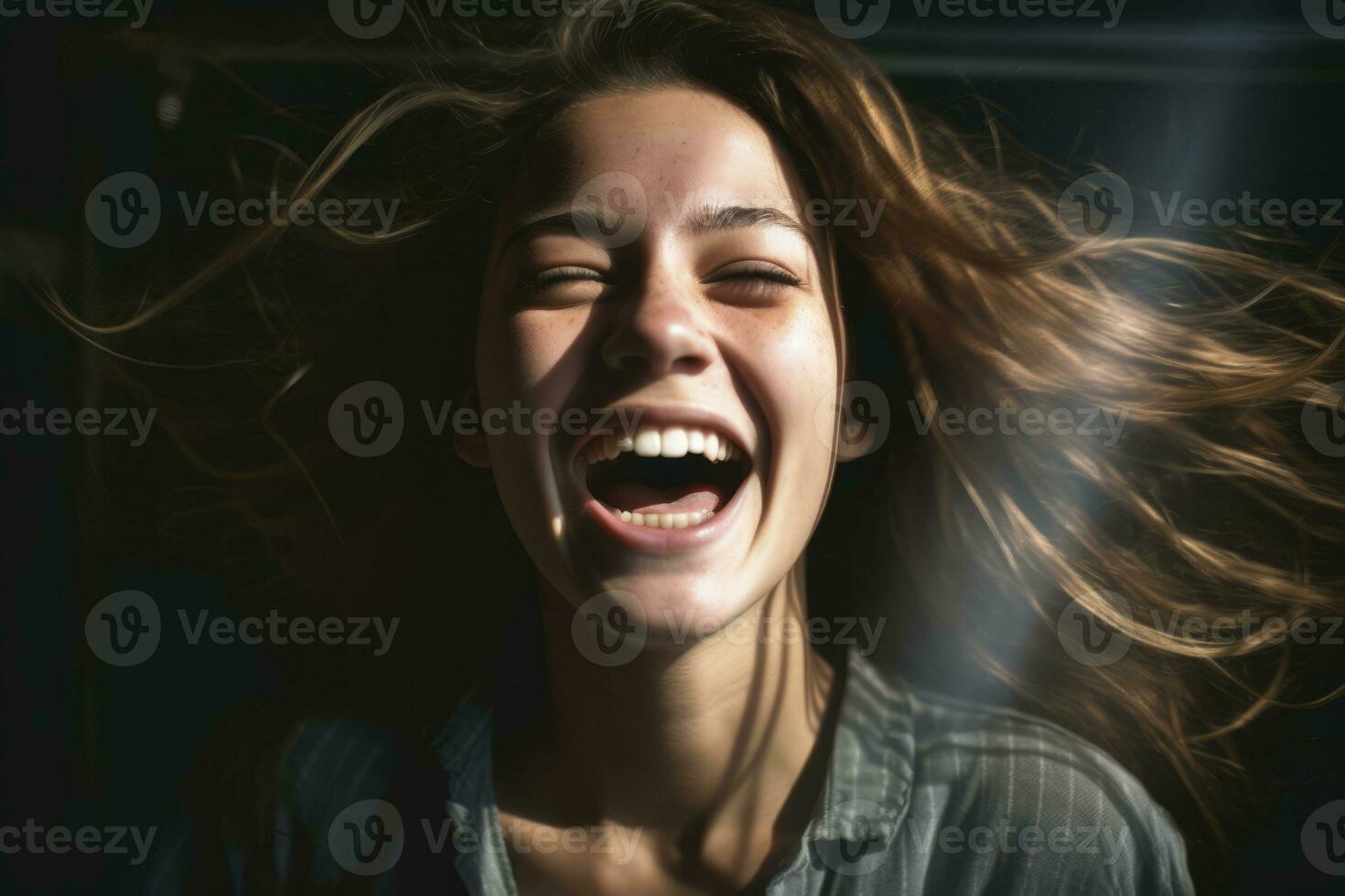 a woman laughing with her hair blowing in the wind photo