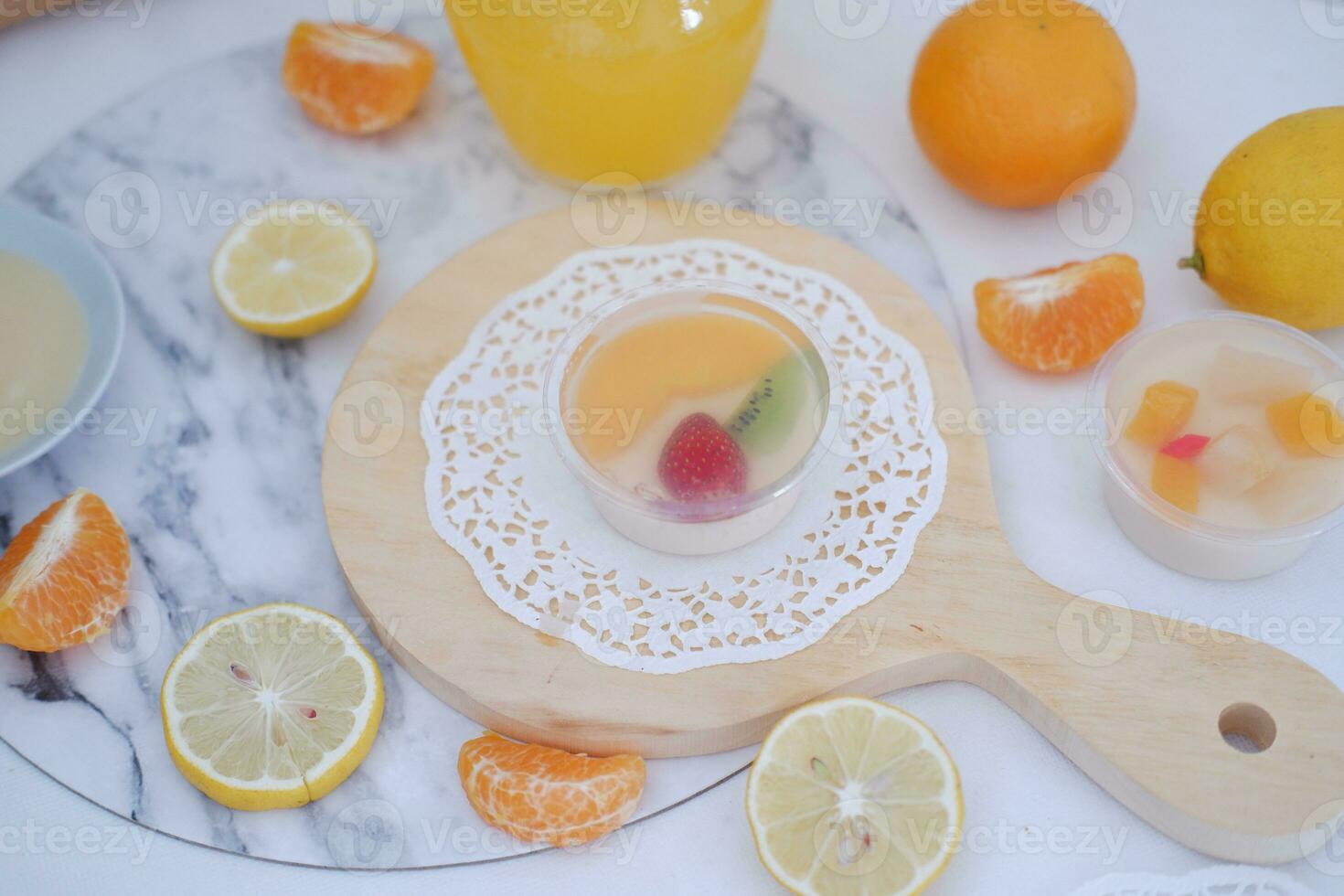 Fruit jelly with orange juice, lemon and kiwi on the table photo