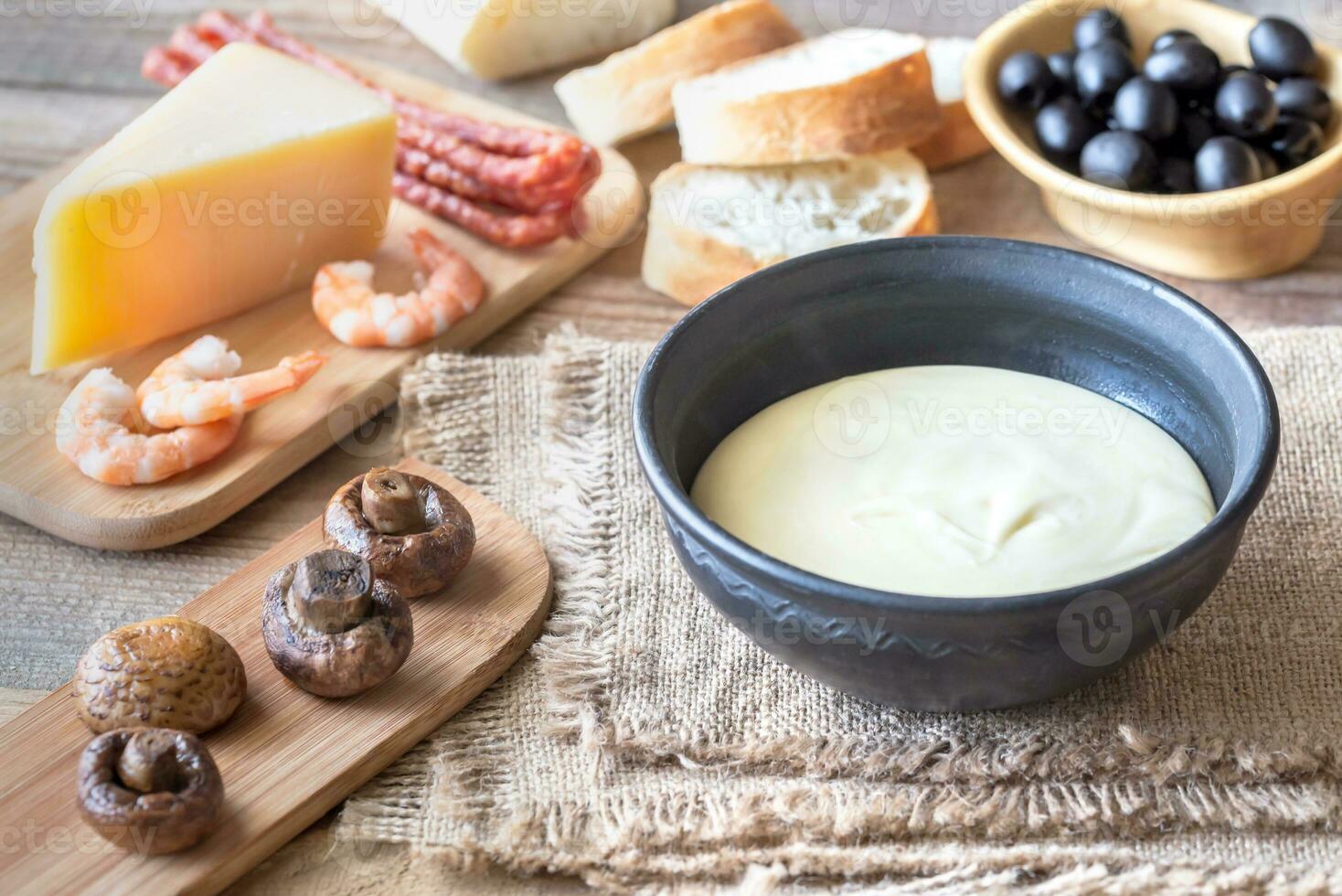 Bowl of fondue with appetizers photo