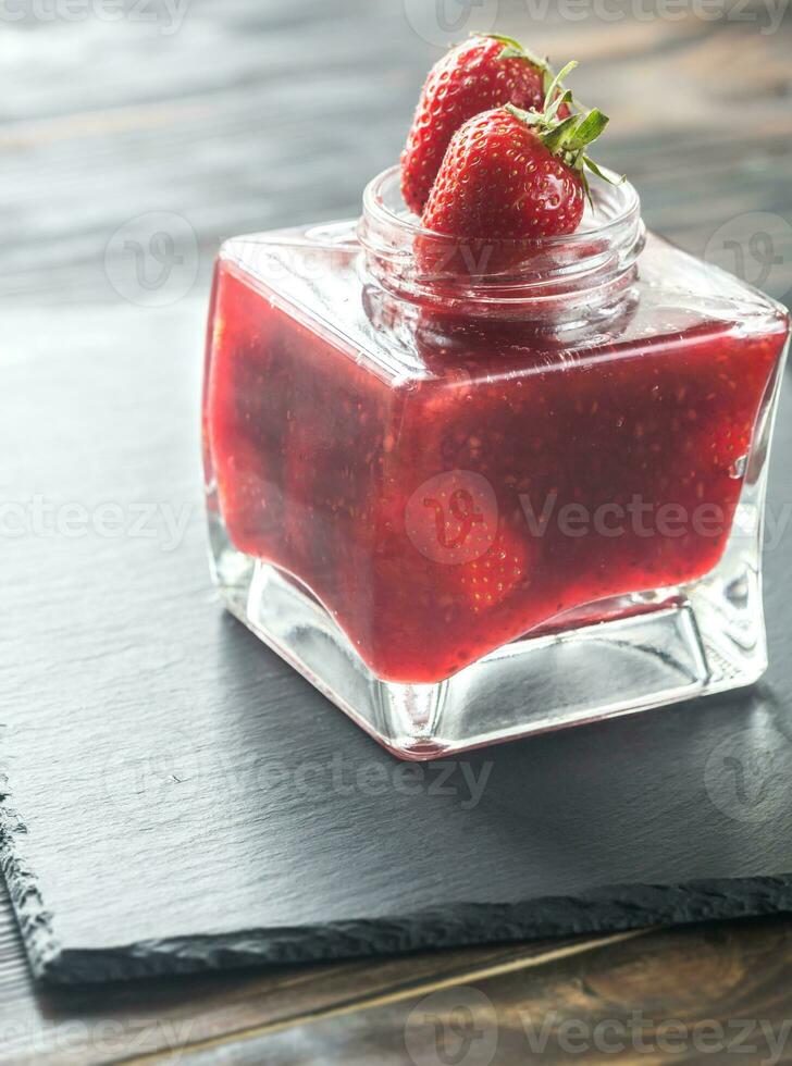 Glass jar of strawberry jam photo