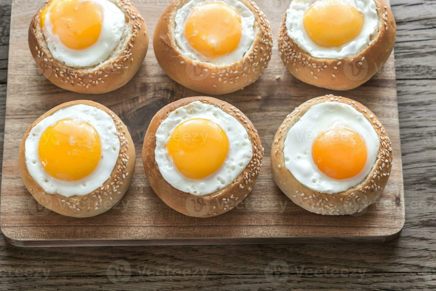 Egg-in-a-hole buns on the wooden board photo