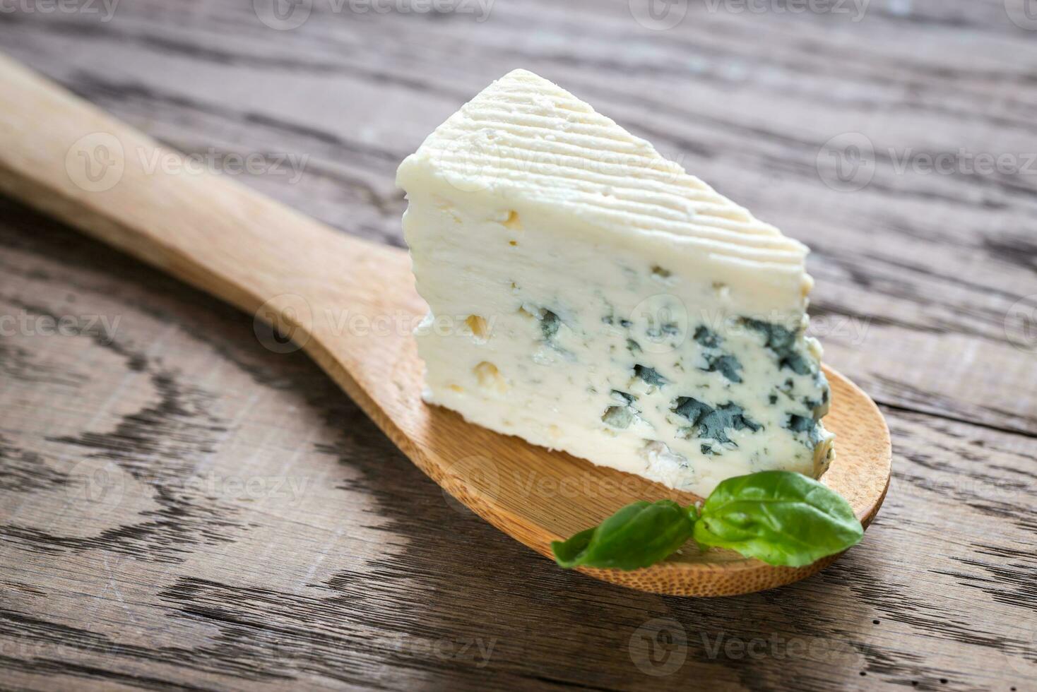 Piece of the blue cheese on the wooden spoon photo