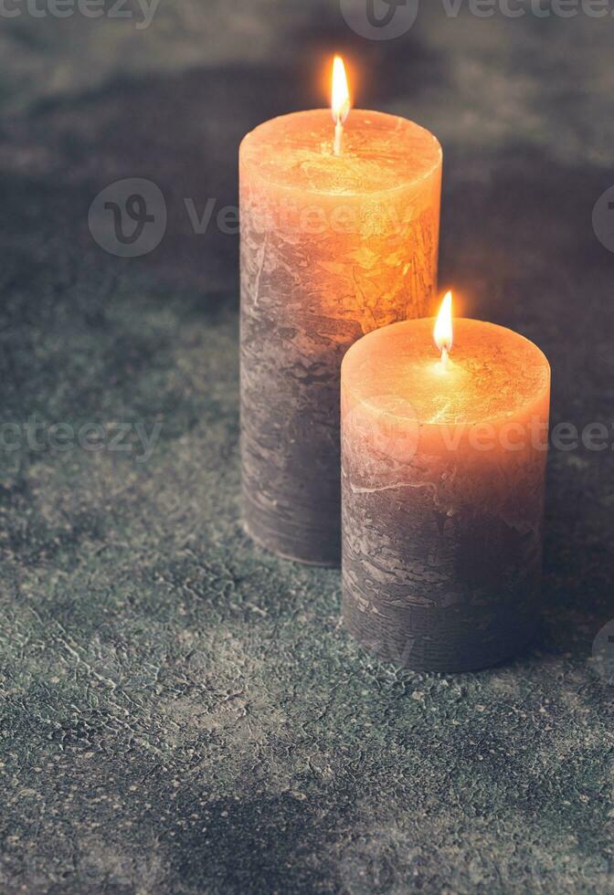 Two burning candles on gray background photo