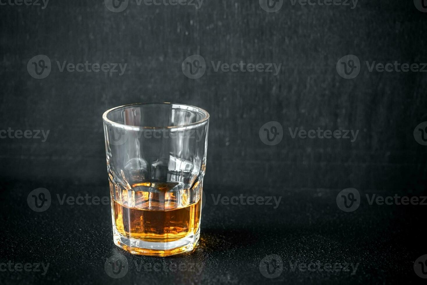 Glass of rum on the dark background photo