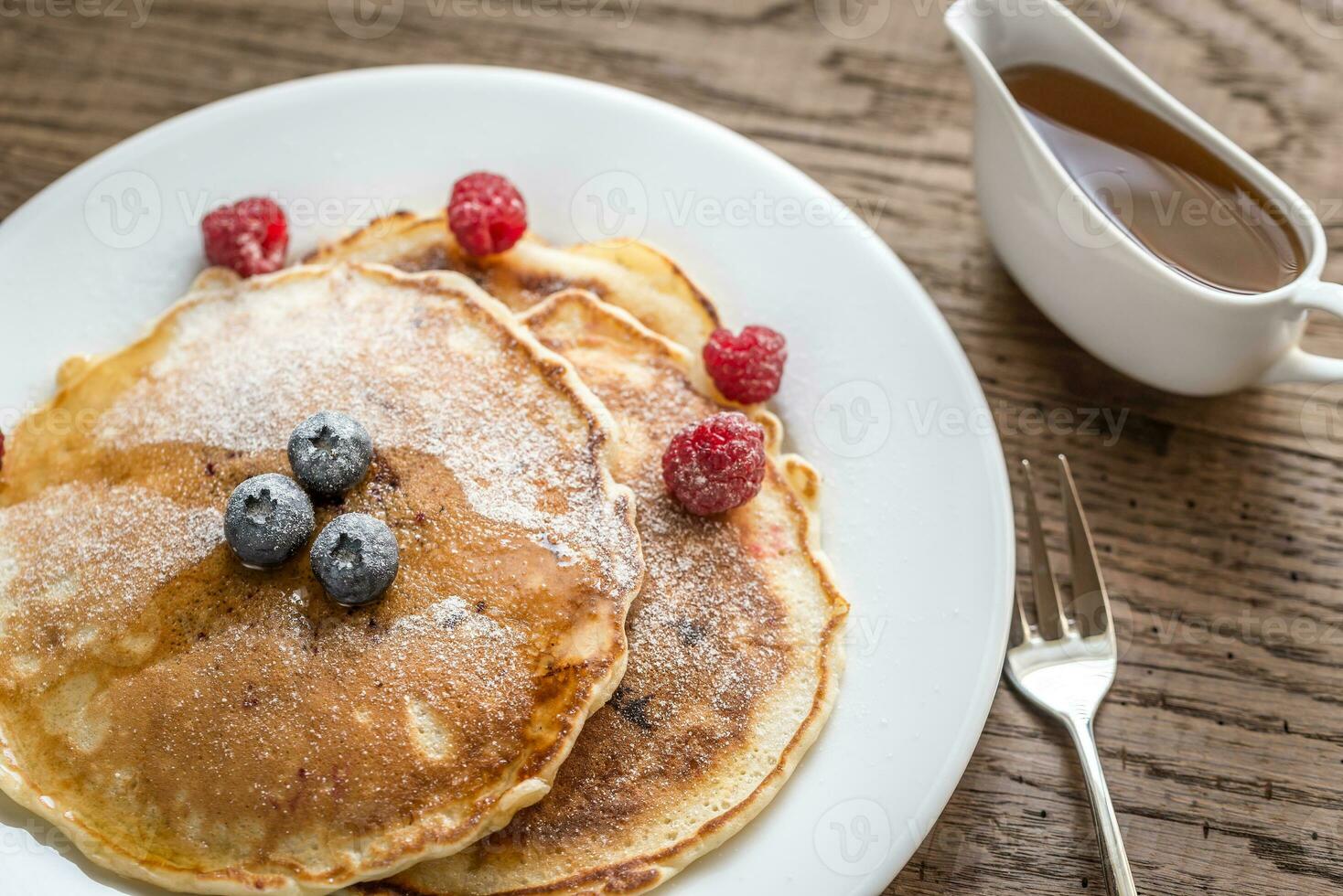 Pancakes with maple syrup and fresh berries photo