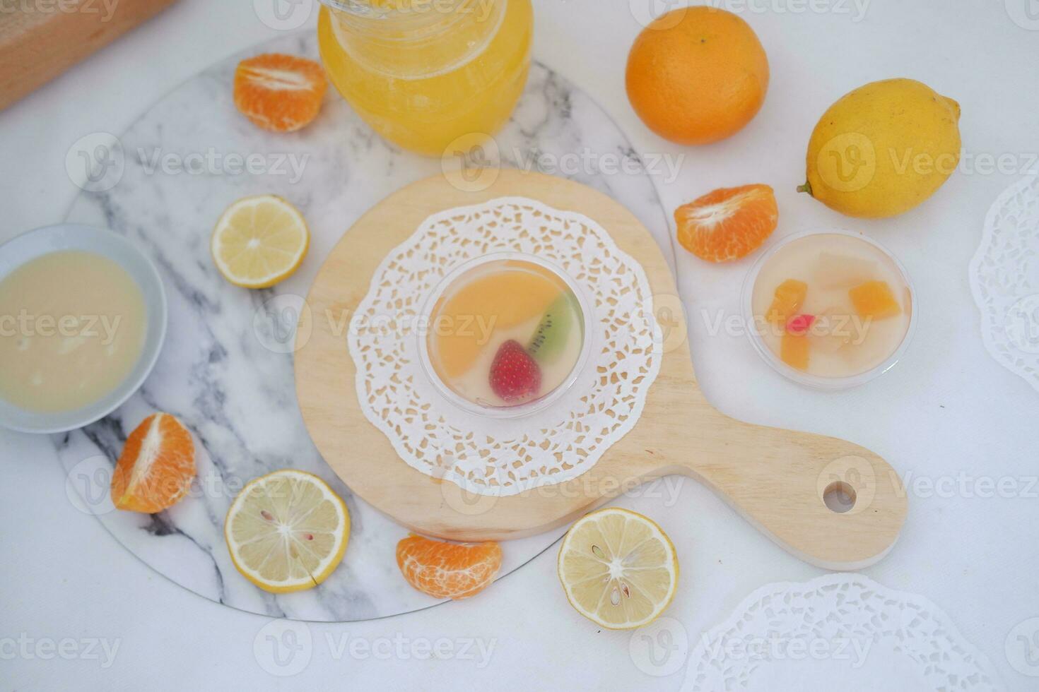 Fruit jelly with orange juice, lemon and kiwi on the table photo